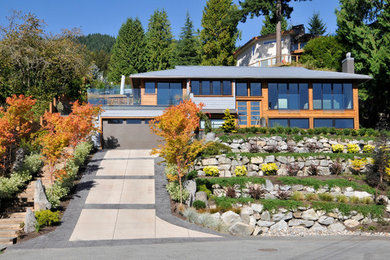 Inspiration for a blue and large contemporary two floor detached house in Vancouver with wood cladding, a hip roof and a metal roof.