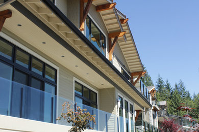 Diseño de fachada beige clásica renovada grande de tres plantas con revestimiento de aglomerado de cemento