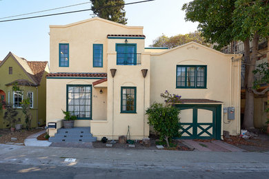 Large transitional yellow split-level stucco exterior home photo in San Francisco with a tile roof