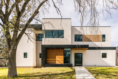 Inspiration for a mid-sized contemporary white two-story stucco exterior home remodel in Austin with a metal roof