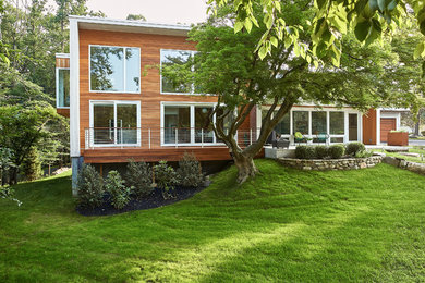 Foto della facciata di una casa multicolore moderna a due piani di medie dimensioni con rivestimento in legno e copertura mista
