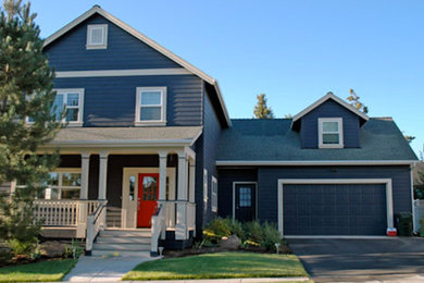 Imagen de fachada de casa bifamiliar azul tradicional grande de dos plantas con revestimiento de madera, tejado a dos aguas y tejado de teja de madera