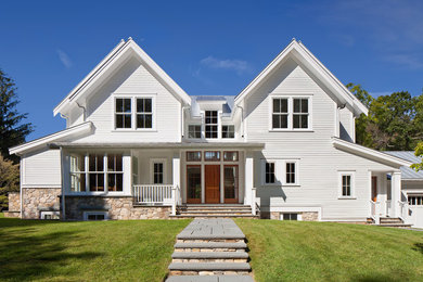 Example of a cottage white concrete fiberboard gable roof design in Boston with a metal roof