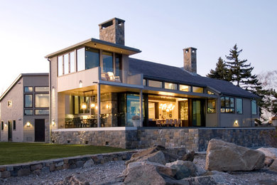 На фото: большой, двухэтажный дом в стиле модернизм с комбинированной облицовкой и односкатной крышей с