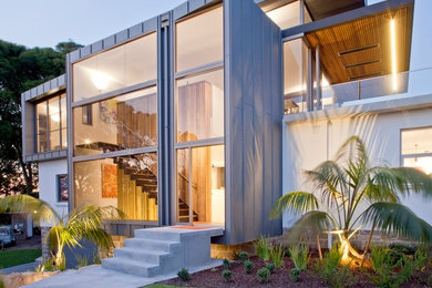 Ejemplo de fachada de casa gris contemporánea de dos plantas con revestimientos combinados y tejado plano