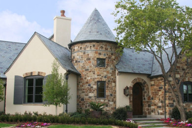 Inspiration for a large timeless beige two-story stucco exterior home remodel in Other with a tile roof