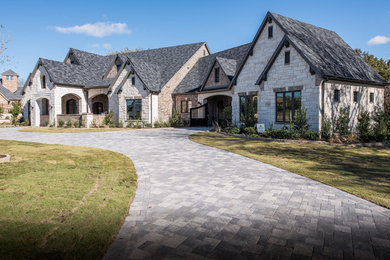 Inspiration for a large transitional multicolored one-story stone exterior home remodel in Dallas with a shingle roof