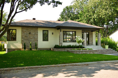 Imagen de fachada de casa beige actual de tamaño medio de una planta con revestimientos combinados, tejado plano y tejado de teja de madera