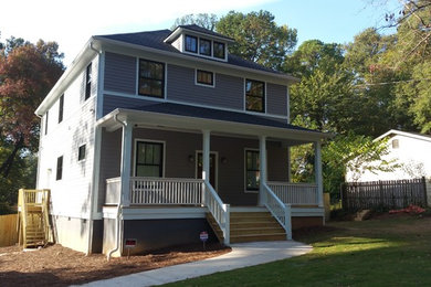 Diseño de fachada de casa gris de estilo americano grande de dos plantas con revestimiento de madera y tejado de teja de madera