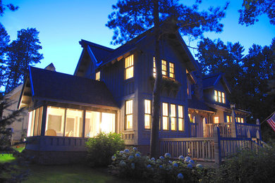 Réalisation d'une façade de maison grise chalet en bois de taille moyenne et à un étage avec un toit à deux pans.