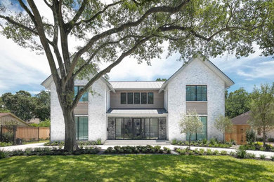 Inspiration for a huge cottage white two-story brick exterior home remodel in Houston with a metal roof