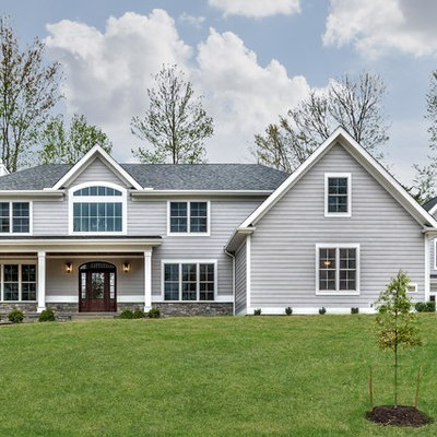 Large traditional gray two-story concrete fiberboard house exterior idea in Other with a hip roof and a shingle roof
