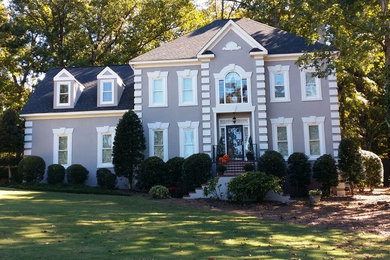 Large elegant beige two-story stucco exterior home photo in Atlanta with a hip roof