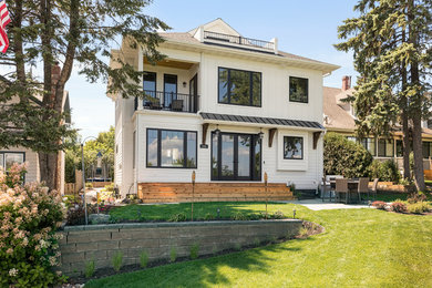 Cette image montre une façade de maison blanche traditionnelle à un étage avec un toit à quatre pans et un toit en shingle.