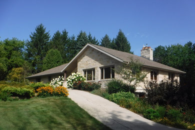 Large elegant beige split-level stone exterior home photo in Milwaukee