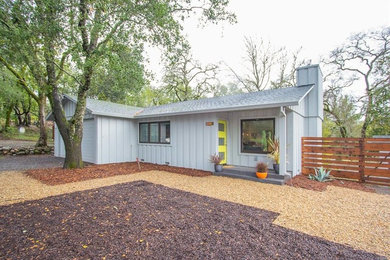 Ejemplo de fachada de casa gris moderna de tamaño medio de una planta con revestimiento de madera, tejado a dos aguas y tejado de teja de madera