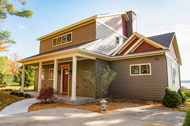 Imagen de fachada de casa multicolor contemporánea de tamaño medio de dos plantas con revestimiento de metal, tejado a dos aguas y tejado de teja de madera