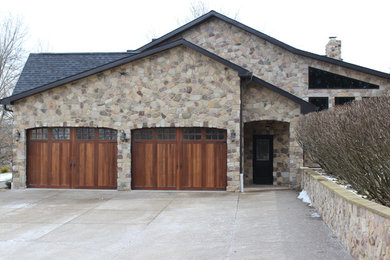 Large mountain style beige two-story stone exterior home photo in Other with a shingle roof