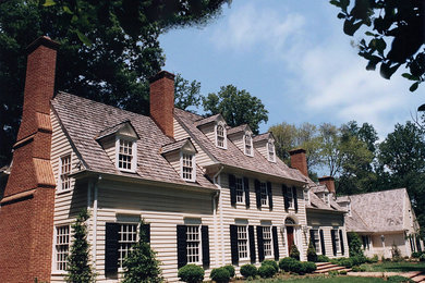 Exemple d'une grande façade de maison beige chic en bois à deux étages et plus avec un toit à deux pans.