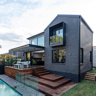 Inspiration for a large contemporary two-storey brick black house exterior in Sydney with a gable roof and a metal roof.