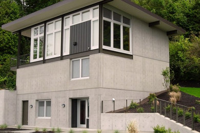 Large gray three-story concrete flat roof idea in Seattle
