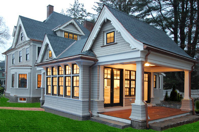 Esempio della villa grande verde classica a un piano con rivestimento in legno, tetto a capanna e copertura a scandole