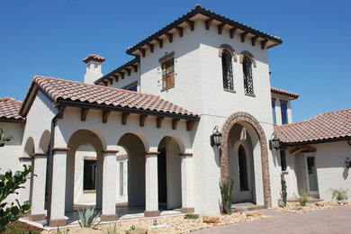 Example of a mid-sized tuscan white two-story stucco exterior home design in Orlando with a hip roof