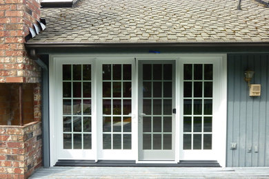 Imagen de fachada azul clásica de tamaño medio con revestimiento de madera