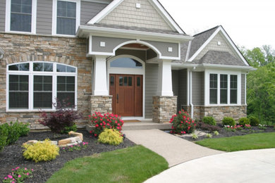 Foto de fachada beige de estilo americano de tamaño medio de dos plantas con revestimientos combinados y tejado a dos aguas
