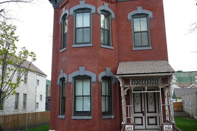 Cette image montre une façade de maison rouge en brique de taille moyenne et à un étage.