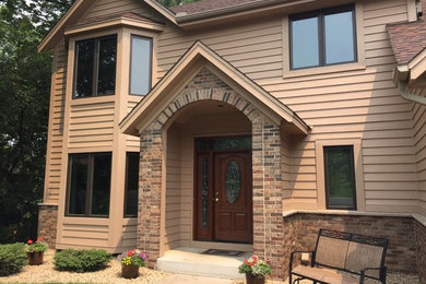 Example of a classic beige wood exterior home design in Minneapolis