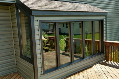 Diseño de fachada de casa verde tradicional de tamaño medio con revestimiento de vinilo, tejado a dos aguas y tejado de teja de madera