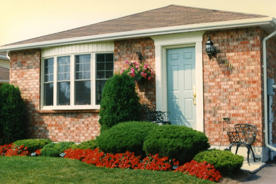 Exemple d'une façade de maison marron en brique de plain-pied avec un toit à deux pans.