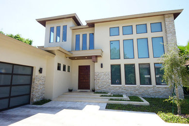 Ejemplo de fachada beige contemporánea grande de dos plantas con revestimiento de estuco y tejado plano