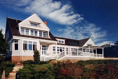 Modelo de fachada de casa beige clásica grande de dos plantas con revestimiento de madera, tejado a dos aguas y tejado de teja de madera