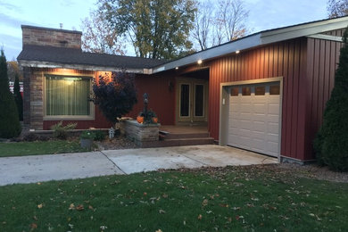 Inspiration for a large timeless red one-story vinyl exterior home remodel in Other