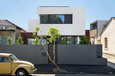 Esempio della facciata di una casa a schiera bianca contemporanea a tre piani di medie dimensioni con rivestimento in mattoni, tetto piano e copertura in metallo o lamiera