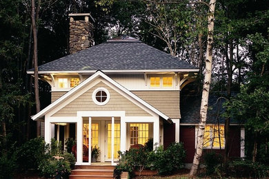 Cette photo montre une grande façade de maison beige craftsman en bois à un étage avec un toit à quatre pans et un toit en shingle.