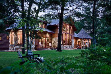На фото: двухэтажный, деревянный, коричневый, большой частный загородный дом в стиле рустика с двускатной крышей и крышей из гибкой черепицы с