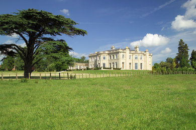 Photo of an expansive and beige classic house exterior in Cheshire with three floors and stone cladding.