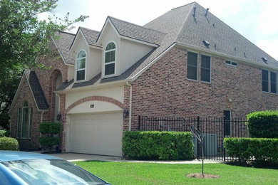 This is an example of a large and red contemporary two floor brick house exterior in Houston.