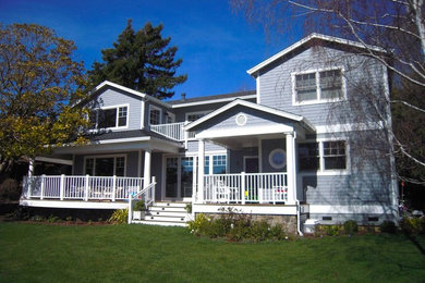 Diseño de fachada de casa gris tradicional de tamaño medio de dos plantas con revestimiento de madera, tejado a dos aguas y tejado de teja de madera