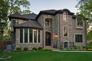 На фото: двухэтажный дом в классическом стиле с облицовкой из камня