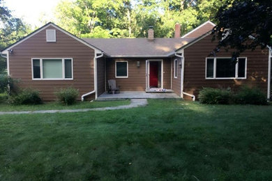 Large elegant brown split-level wood house exterior photo in New York