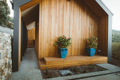 Imagen de fachada de casa contemporánea con revestimiento de madera y tejado de metal