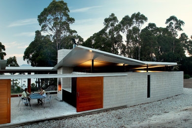 Mittelgroßes, Einstöckiges Mid-Century Haus mit Betonfassade und grauer Fassadenfarbe in Hobart