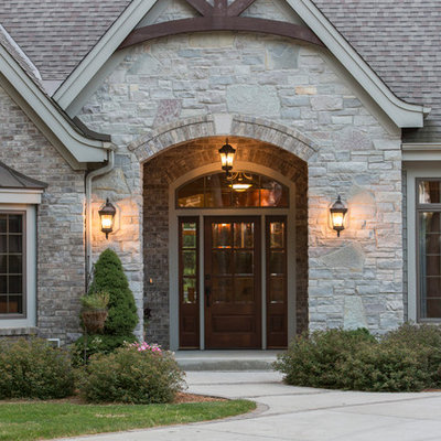 Huge traditional beige one-story stone exterior home idea in Milwaukee with a shingle roof