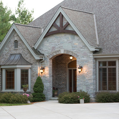 Inspiration for a huge timeless beige one-story stone exterior home remodel in Milwaukee with a shingle roof