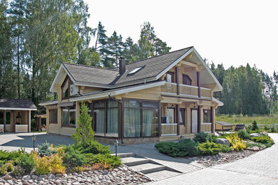 На фото: деревянный, бежевый дом в стиле рустика с двускатной крышей с
