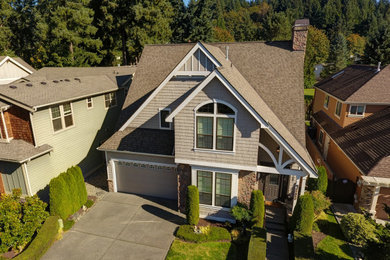 Ejemplo de fachada de casa beige de estilo americano de tamaño medio de dos plantas con revestimiento de madera, tejado a dos aguas y tejado de teja de madera